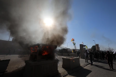 Người biểu tình phóng hỏa bên ngoài Đại sứ quán Mỹ ở Baghdad, Iraq ngày 31/12/2019. (Ảnh: THX/TTXVN)