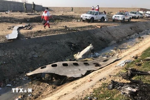 Lực lượng chức năng làm nhiệm vụ tại hiện trường máy bay Boeing 737-800 của Hãng hàng không quốc tế Ukraine rơi gần sân bay Imam Khomeini ở Tehran, Iran ngày 8/1/2020. (Ảnh: IRNA/TTXVN)