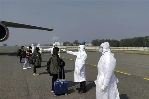 Kiểm tra thân nhiệt những hành khách trở về từ Vũ Hán, Trung Quốc. (Ảnh minh họa. AFP/TTXVN)