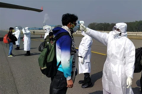 Kiểm tra thân nhiệt những hành khách trở về từ Vũ Hán, Trung Quốc, tại sân bay New Delhi, Ấn Độ, ngày 2/2/2020. (Ảnh: AFP/TTXVN)