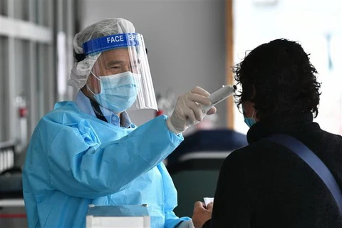 Nhân viên y tế kiểm tra thân nhiệt cho một bệnh nhân tại bệnh viện Princess Margaret ở Hong Kong ngày 4/2/2020. (Ảnh: AFP/TTXVN)