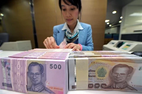 Kiểm đồng baht Thái tại ngân hàng ở Bangkok, Thái Lan. (Ảnh: AFP/TTXVN)