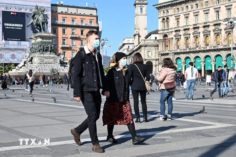 Khách thăm quan đeo khẩu trang phòng dịch COVID-19 tại quảng trường del Duomo, Milan, Italy ngày 24/2/2020. (Ảnh: AFP/TTXVN)