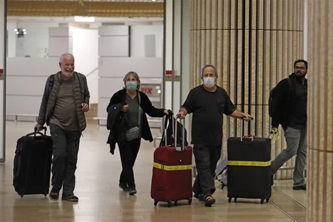 Hành khách di chuyển tại sân bay. (Ảnh: AFP/TTXVN)