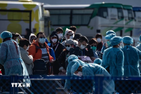 Hành khách được kiểm tra thân nhiệt trước khi rời khỏi du thuyền Diamond Princess tại cảng ở Yokohama, Nhật Bản ngày 21/2/2020. (Ảnh: AFP/TTXVN)