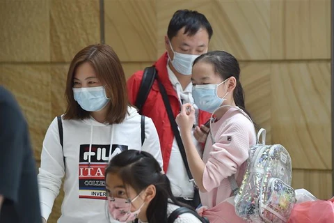 Người dân đeo khẩu trang để phòng tránh lây nhiễm COVID-19 tại sân bay ở Sydney, Australia. (Ảnh: AFP/TTXVN)