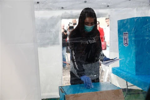 Nhân viên tại điểm bỏ phiếu ở thành phố Tel Aviv, Israel đeo khẩu trang phòng dịch viêm đường hô hấp cấp COVID-19 ngày 1/3/2020. (Ảnh: THX/TTXVN)