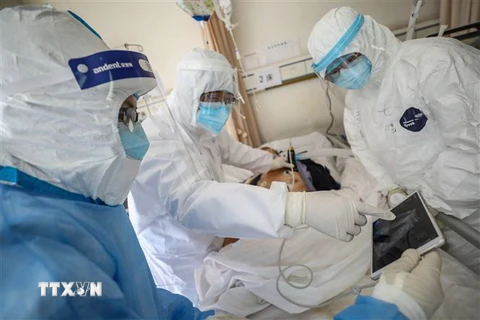 Nhân viên y tế điều trị cho bệnh nhân nhiễm COVID-19 tại bệnh viện ở Vũ Hán, Trung Quốc. (Ảnh: AFP/TTXVN)