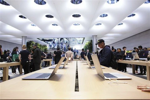 Khách hàng trải nghiệm các sản phẩm của Apple tại cửa hàng ở New York, Mỹ. (Ảnh: AFP/TTXVN)