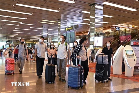 Đeo khẩu trang để phòng tránh lây nhiễm COVID-19 tại sân bay quốc tế Changi, Singapore. (Ảnh: AFP/TTXVN)