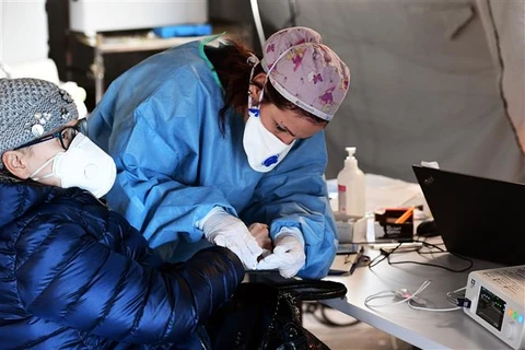 Trợ giúp y tế cho người dân tại trại tạm bên ngoài bệnh viện Cremona, miền Bắc Italy ngày 4/3/2020. (Ảnh: AFP/TTXVN)