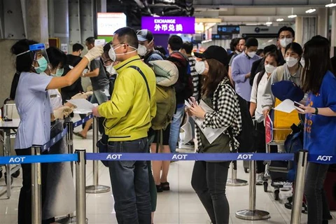 Nhân viên y tế kiểm tra thân nhiệt hành khách tại sân bay quốc tế Suvarnabhumi ở Bangkok, Thái Lan ngày 9/3/2020. (Ảnh: AFP/TTXVN)