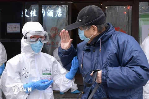 Bệnh nhân nhiễm COVID-19 tạm biệt bác sĩ sau khi được chữa khỏi tại bệnh viện ở Vũ Hán, tỉnh Hồ Bắc, Trung Quốc, ngày 10/3/2020. (Ảnh: THX/TTXVN)