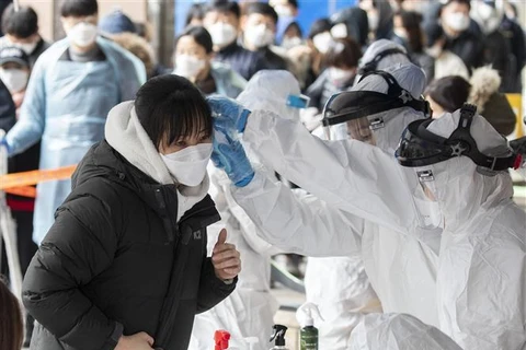 Nhân viên y tế lẫy mẫu bệnh phẩm để xét nghiệm nhằm phát hiện các trường hợp nhiễm dịch COVID-19 ở Seoul, Hàn Quốc ngày 10/3/2020. (Ảnh: THX/TTXVN)