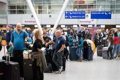 Hành khách chờ đợi tại sân bay. (Ảnh: AFP/TTXVN)