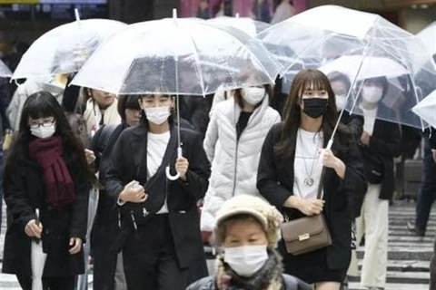 Người dân đeo khẩu trang phòng tránh COVID-19 tại Osaka, Nhật Bản. (Ảnh: Kyodo/TTXVN)