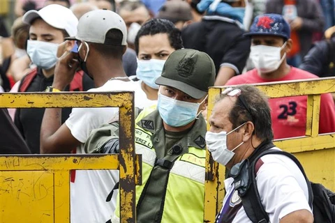Người dân từ Venezuela chờ nhập cảnh tại khu vưc biên giới Colombia và Venezuela, ngày 12/3. (Ảnh: AFP/TTXVN)
