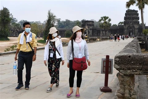 Khách du lịch đeo khẩu trang phòng dịch COVID-19 tại tỉnh Siem Reap, Campuchia. (Ảnh: AFP/TTXVN)