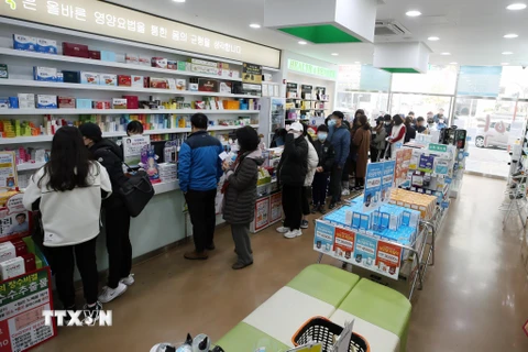 Người dân xếp hàng chờ mua khẩu trang tại một hiệu thuốc ở Gwangju, cách thủ đô Seoul của Hàn Quốc 329km về phía nam, ngày 15/3/2020. (Ảnh: Yonhap/TTXVN)