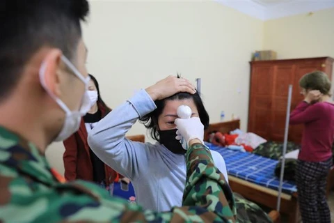 Kiểm tra nhiệt độ thân nhiệt cho từng người mỗi sáng tại khu cách ly tập trung trường quân sự Quảng Ninh. (Ảnh: Thành Đạt/TTXVN)