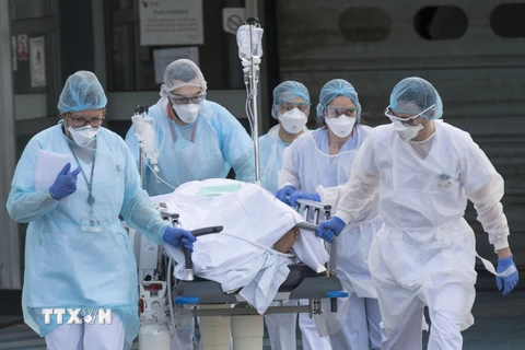 Nhân viên y tế chuyển bệnh nhân khỏi bệnh viện Emile Muller ở Mulhouse, miền Đông Pháp trong bối cảnh dịch COVID-19 bùng phát. (Ảnh: AFP/TTXVN)