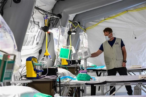 Kỹ thuật viên lắp đặt thiết bị tại bệnh viện dã chiến điều trị cho bệnh nhân COVID-19 ở Cremona, miền Đông Nam Milan, Italy. (Ảnh: AFP/TTXVN)