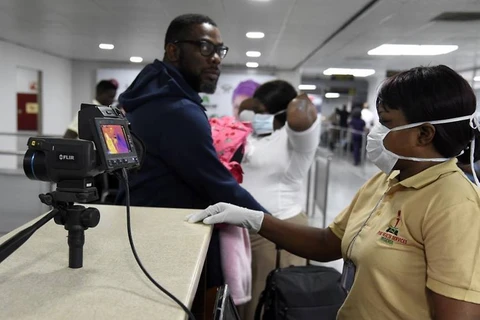 Nhân viên điều khiển máy quét thân nhiệt tại sân bay quốc tế Murtala Mohammed ở Lagos, Nigeria. (Ảnh: AFP) 