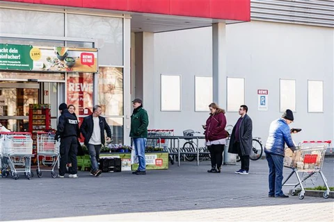 Người dân xếp hàng bên ngoài một siêu thị ở Berlin, Đức, trong bối cảnh dịch COVID-19 lan rộng. (Ảnh: THX/TTXVN)