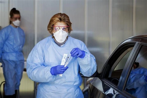 Nhân viên y tế lấy mẫu xét nghiệm COVID-19 tại Amsterdam, Hà Lan. (Ảnh: AFP/TTXVN)