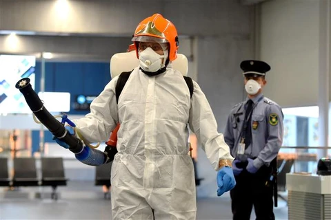 Nhân viên kiểm dịch phun thuốc khử trùng nhằm ngăn chặn sự lây lan của dịch COVID-19 tại sân bay Liszt Ferenc ở Budapest, Hungary. (Ảnh: AFP/TTXVN)