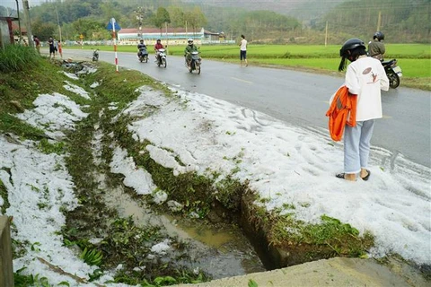 Mưa đá phủ trắng hai bên đường ở Điện Biên. (Ảnh: Xuân Tư/TTXVN)