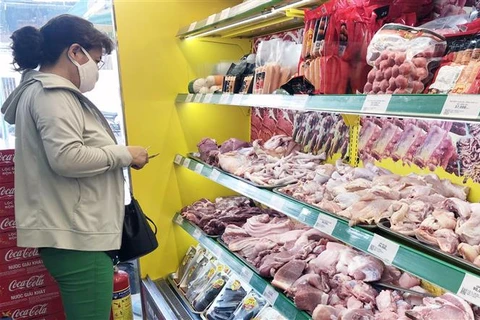 Người tiêu dùng chọn mua thịt lợn. (Ảnh: Mỹ Phương/TTXVN)