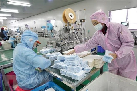 Công nhân may khẩu trang y tế tại một nhà máy ở Trung Quốc. (Ảnh: THX/TTXVN)