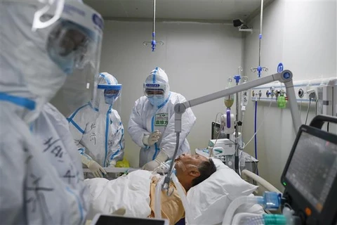 Nhân viên y tế điều trị cho một bệnh nhân nam mắc COVID-19 tại bệnh viện ở Vũ Hán, Trung Quốc. (Ảnh: THX/TTXVN)