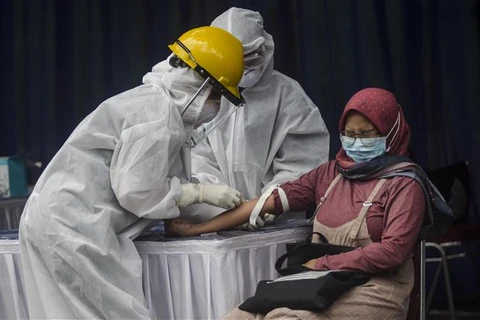 Nhân viên y tế lấy mẫu xét nghiệm COVID-19 cho người dân tại tỉnh Tây Java, Indonesia. (Ảnh: THX/TTXVN)