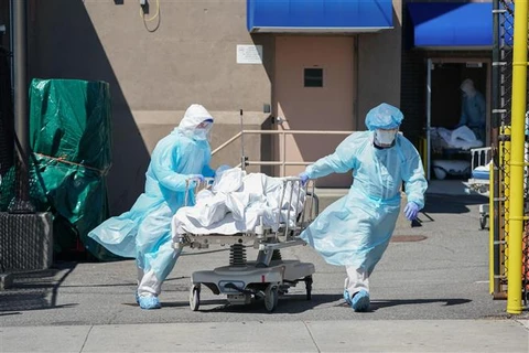 Nhân viên y tế chuyển thi thể bệnh nhân COVID-19 tới nhà xác dã chiến của bệnh viện Wyckoff ở Brooklyn, New York, Mỹ ngày 6/4/2020. (Ảnh: AFP/TTXVN)