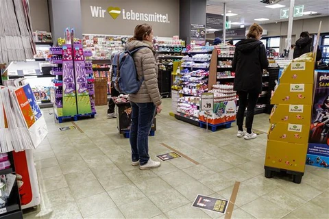 Người dân xếp hàng chờ thanh toán tại siêu thị ở Berlin, Đức, trong bối cảnh dịch COVID-19 lan rộng. (Ảnh: THX/TTXVN)