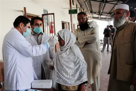 Kiểm tra thân nhiệt phòng lây nhiễm dịch COVID-19 tại Peshawar, Pakistan. (Ảnh: THX/TTXVN)