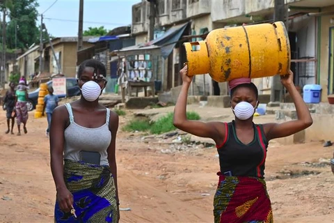 Người dân đeo khẩu trang nhằm ngăn chặn sự lây lan của dịch COVID-19 tại Abidjan, Cote d'Ivoire. (Ảnh: AFP/TTXVN)