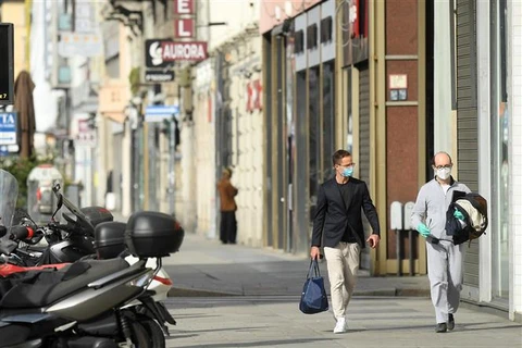 Người dân đeo khẩu trang phòng lây nhiễm COVID-19 tại Milan, Italy. (Ảnh: THX/TTXVN)