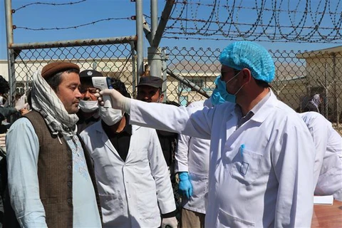 Nhân viên y tế kiểm tra thân nhiệt nhằm ngăn dịch COVID-19 tại Dushi, tỉnh Baghlan, Afghanistan. (Ảnh: THX/TTXVN)