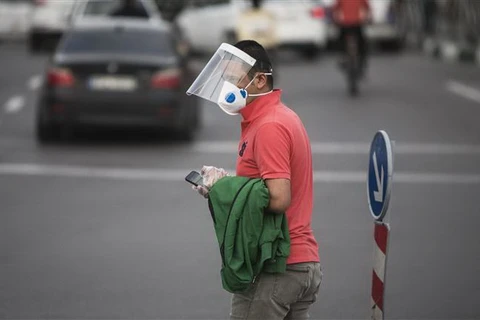 Người dân đeo khẩu trang và mặt nạ phòng lây nhiễm COVID-19 tại Tehran, Iran. (Ảnh: THX/TTXVN)