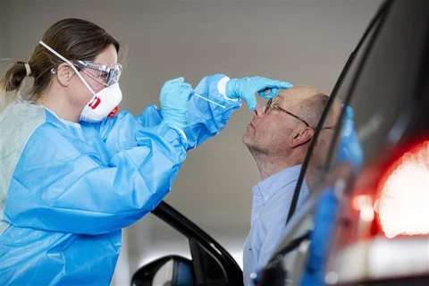 Nhân viên y tế lấy mẫu xét nghiệm COVID-19 tại Rotterdam, Hà Lan. (Ảnh: AFP/TTXVN)