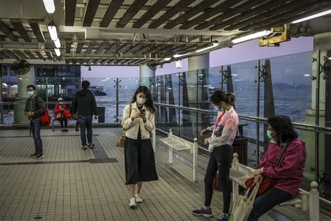 Người dân đeo khẩu trang phòng lây nhiễm COVID-19 tại Hong Kong, Trung Quốc. (Ảnh: AFP/TTXVN)