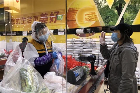 Người dân đeo khẩu trang để phòng tránh lây nhiễm COVID-19 khi mua hàng hóa tại siêu thị ở Falls Church, Virginia, Mỹ. (Ảnh: THX/TTXVN)