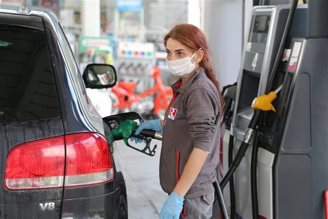 Nhân viên bơm xăng cho phương tiện tại một trạm xăng ở Nicosia, Cộng hòa Cyprus ngày 4/5/2020. (Ảnh: THX/TTXVN)