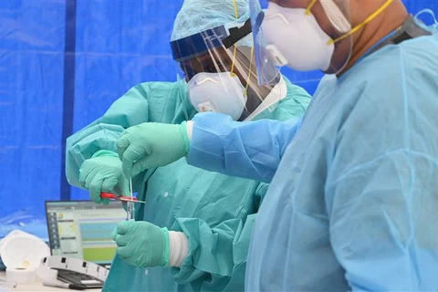 Nhân viên y tế kiểm tra bộ kit xét nghiệm COVID-19 tại New York, Mỹ, ngày 8/5/2020. (Ảnh: AFP/TTXVN)