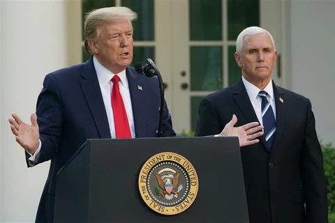 Tổng thống Mỹ Donald Trump (trái) và Phó Tổng thống Mike Pence trong cuộc họp báo về dịch COVID-19 tại Nhà Trắng ngày 27/4/2020. (Ảnh: AFP/ TTXVN)