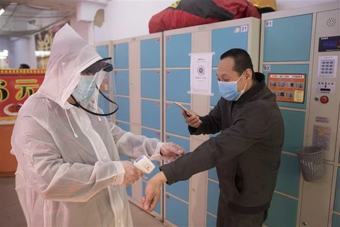 Kiểm tra thân nhiệt và mã sức khỏe nhằm ngăn chặn sự lây lan của COVID-19 tại Hắc Long Giang, Trung Quốc. (Ảnh: THX/TTXVN)