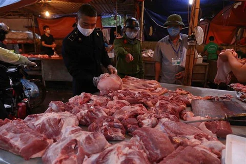 Lực lượng chức năng kiểm tra việc kinh doanh thịt lợn tại chợ đầu mối Minh Khai, Hà Nội. (Ảnh: Vũ Sinh/TTXVN)